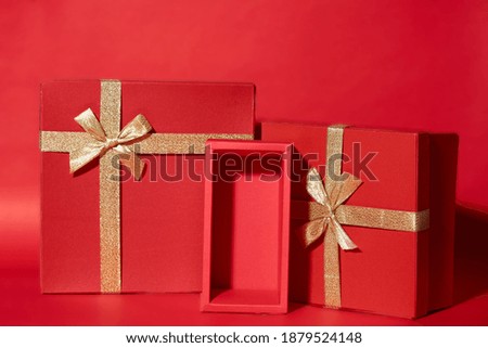 Gift red boxes gold ribbon on red background. Valentines day or Christmas celebration concept. 