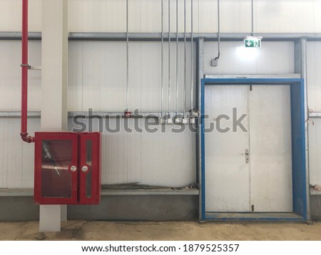 Fire extinguisher box with fire hose inside and emergency exit