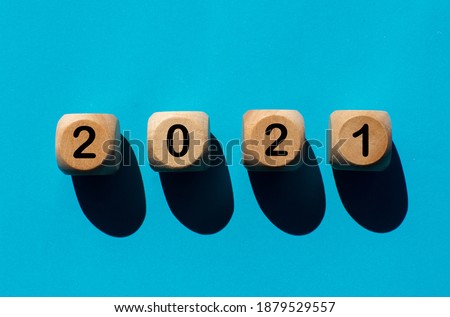 Numbers 2021 on wooden cubes on turquoise background Concept Happy New Year start
