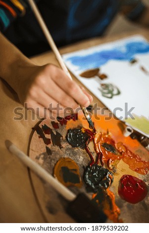 Cute little boy painting a picture in home studio