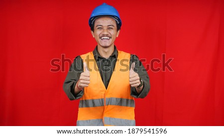 asian construction worker man wearing uniform, helmet with ok gesture isolated red background