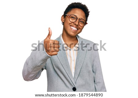 Young african american woman wearing business clothes doing happy thumbs up gesture with hand. approving expression looking at the camera showing success. 
