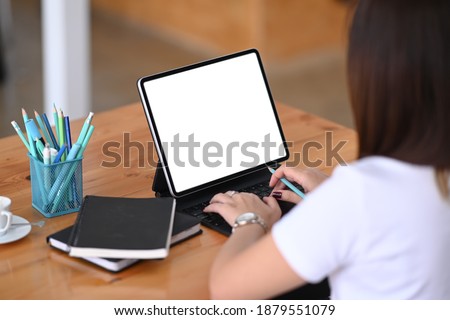 Rear view of female designer working with computer tablet at her creative workspace.