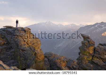 A photographer taking a picture just before sunset in the Rocky Mountains.