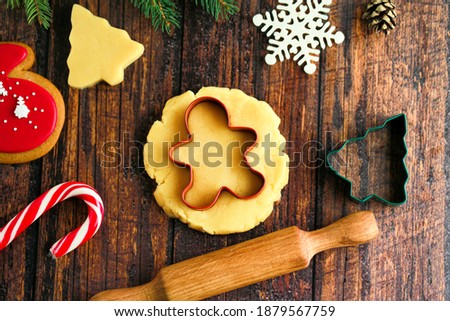 Gingerbread man made from gingerbread.decoration on a wooden background.Cooking Christmas gingerbread on a dark background.Christmas homemade gingerbread cookies on the table.Christmas cookies cooking