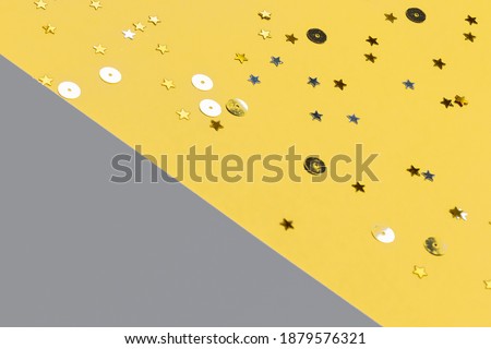 Gray and yellow festive background with confetti. Color of the year 2021.