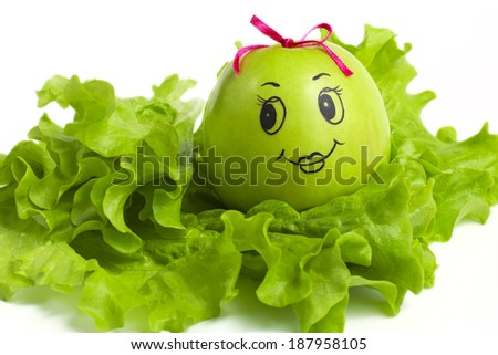 apple with comically painted face on a white background