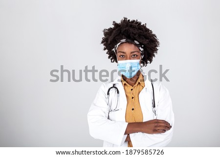 Medical concept of young beautiful female doctor in white coat with phonendoscope, waist up. Woman hospital worker looking at camera with protective face mask, studio, grey background