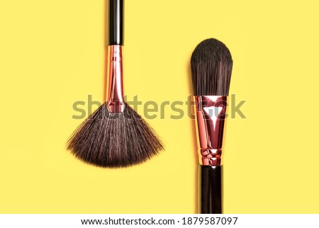 Professional makeup brushes on Illuminating yellow background flat lay top view. Pantone color of year 2021. Beauty product, makeup, women's accessory, fashion. Different brushes. Cosmetic makeup Set