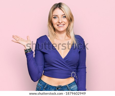 Young caucasian woman wearing casual clothes smiling cheerful presenting and pointing with palm of hand looking at the camera. 