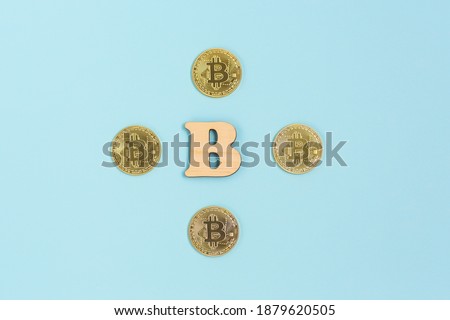 Bitcoins next to wooden B letter. Bitcoins and the new concept of virtual money.