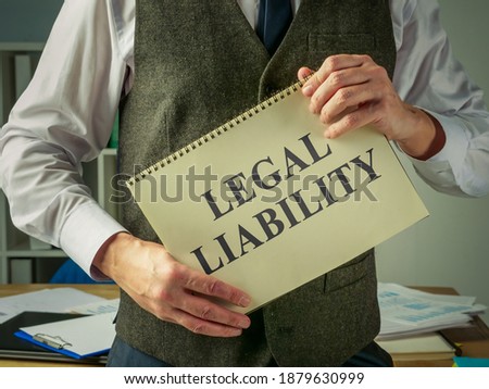 The clerk holds a book about legal liability.