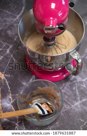 bowl with chocolate next to a mixer on a dark marble background