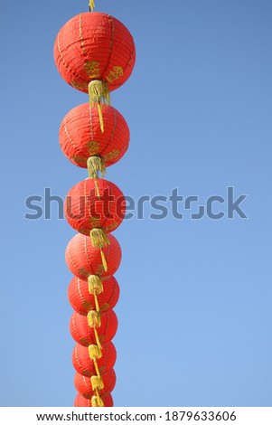 Red Chinese lanterns on a blue sky background, Chinese people tend to hang lanterns to decorate their homes or shrines during special festivals such as Chinese New Year.

