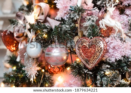 pink christmas decoration, postcard. on the tree a heart, balls and a garland.
