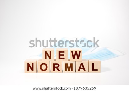 NEW NORMAL text on wooden cube. Wooden cubes with NEW NORMAL word. Adapting to new life or business post-lockdown after coronavirus pandemic. Business with social distancing personal hygiene.