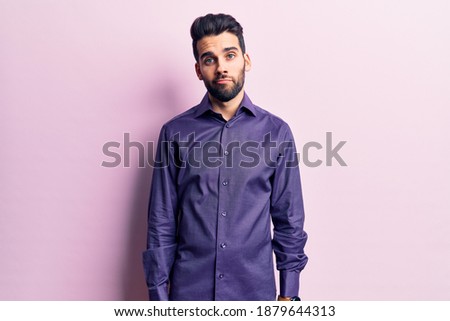 Young handsome man with beard wearing casual shirt looking sleepy and tired, exhausted for fatigue and hangover, lazy eyes in the morning. 