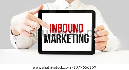 Text Inbound Marketing on tablet display in businessman hands on the white bakcground. Business concept