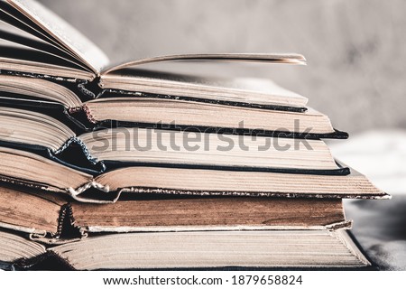 Opened books in a stack on a light home background. Education, hobbies