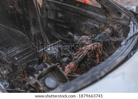 Badly burnt parked car on the road