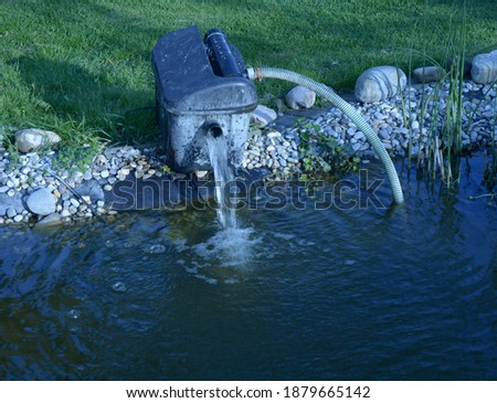 big electric water pump outdoor at the edge of the pond for cleaning and overhaul