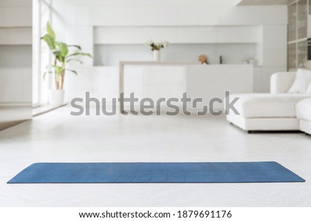Space for yoga class at home. Exercise mat for yoga, fitness or workout practice at home, living room background. wellness concept. Copy space Royalty-Free Stock Photo #1879691176