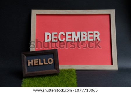 Hello december word wooden in frame on black background. Business, weekend, holiday or new year planning concept.