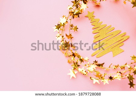 Golden and white glitter decoration and pink background. Celebration minimal Christmas tree.