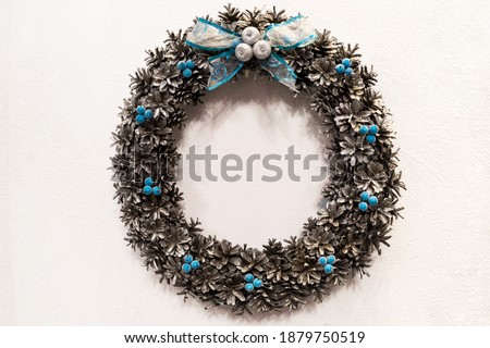 Christmas wreath on the wall or door, white background, wreath made by hand. Symbol of Christmas.