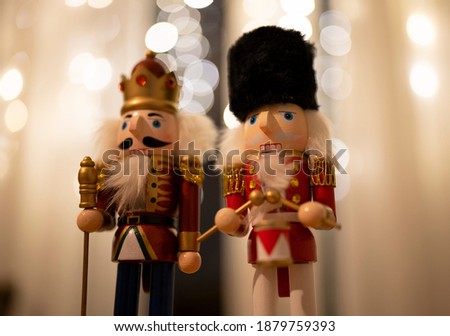 Two Christmas Holidays Nutcrackers next to each other at night with cozy bokeh lights at the background