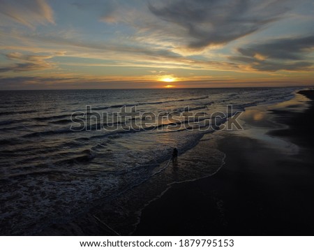 Sunset on Atlantic ocean Argentine coasts, brown sand and waves, picture with a drone