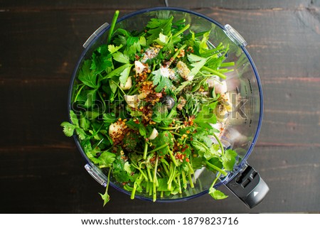 Chimichurri Ingredients in a Food Processor: Parsley, cilantro, garlic, and other chimichurri ingredients in a food processor bowl Royalty-Free Stock Photo #1879823716