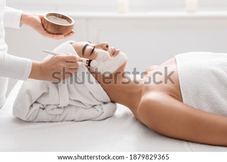Skin Lifting Treatment. Young asian woman getting facial nourishing mask by professional beautician at spa salon, calm lady enjoying wellness day and beauty procedures, side view with copy space Royalty-Free Stock Photo #1879829365