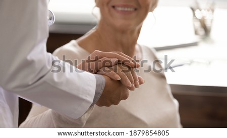 Close up view of supportive female nurse comfort caress touch hold mature patient hand. Woman doctor support take care of senior client at consultation, show empathy and love. Healthcare concept. Royalty-Free Stock Photo #1879854805