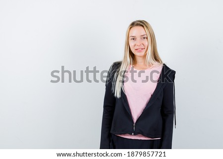  blonde lady in t-shirt, jacket looking at camera and looking elegant , front view. 