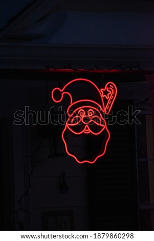 A Santa Claus Christmas red neon sign (vertical).