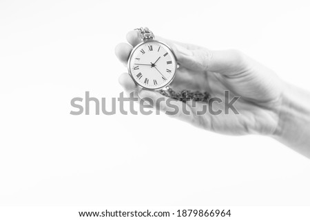Old pocket watch in a female hand on a white background.