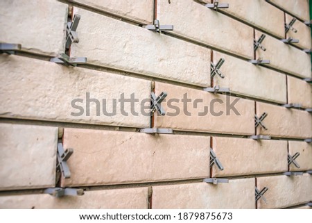 Installation of tiles with crosses on the wall.