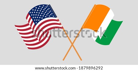 Crossed and waving flags of Republic of Ivory Coast and the USA