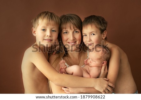 Family portrait - mother and three sons: two school-age child and newborn baby.