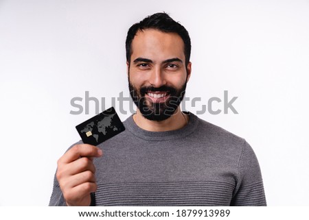 Happy young Arabian man holding credit card isolated over white background