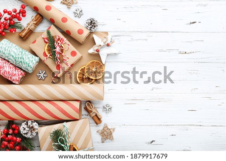Gift boxes with ornaments on white wooden background