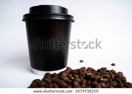 white background black cardboard cup and coffee beans