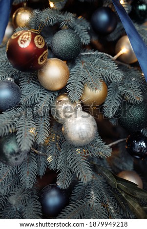 Photo of golden silver balls pretty modern decorations hanging on green tree before on christmas holidays