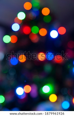 Festive feel of defocused colored lights for backgrounds or abstract use in Christmas tree shape.