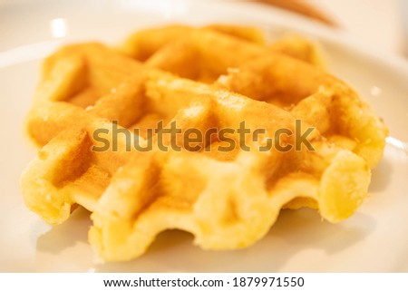 A waffle is on a white plate.