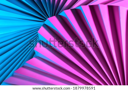 Geometric background of partially blurred paper fans. Pink and blue abstract background. Three-dimensional paper objects in neon lighting. Sometimes blurry image of geometric objects.