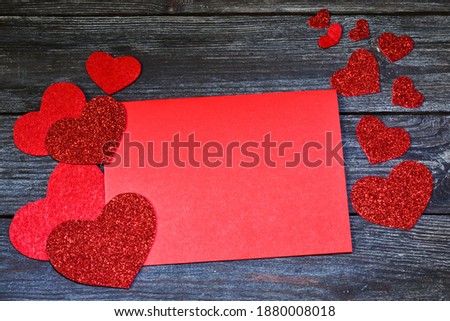 Greeting card with a red hearts and paper space for text on a wooden background.  Copy space, flat lay. Valentine's Day.