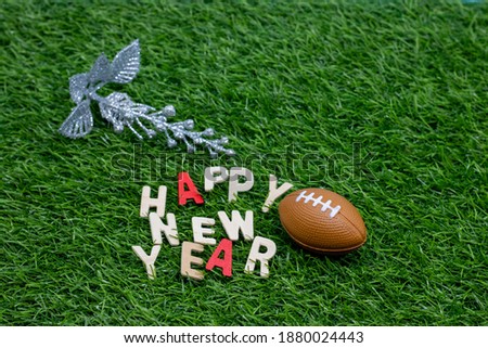American Football with Happy New Year word on green grass