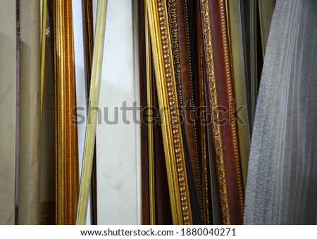 Wooden frame, golden lines, antique patterns, brown in many ways, arranged together as a tool for making picture frames in a shop or factory to decorate the building for beauty.